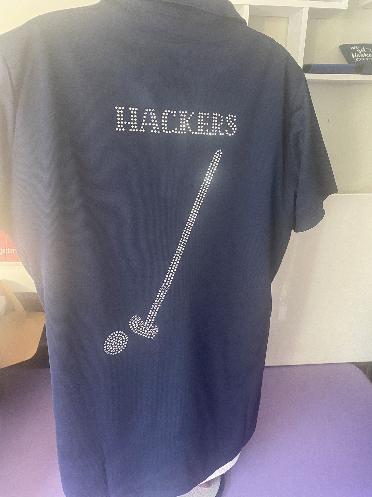 The back of a black t-shirt with the word hackers on it