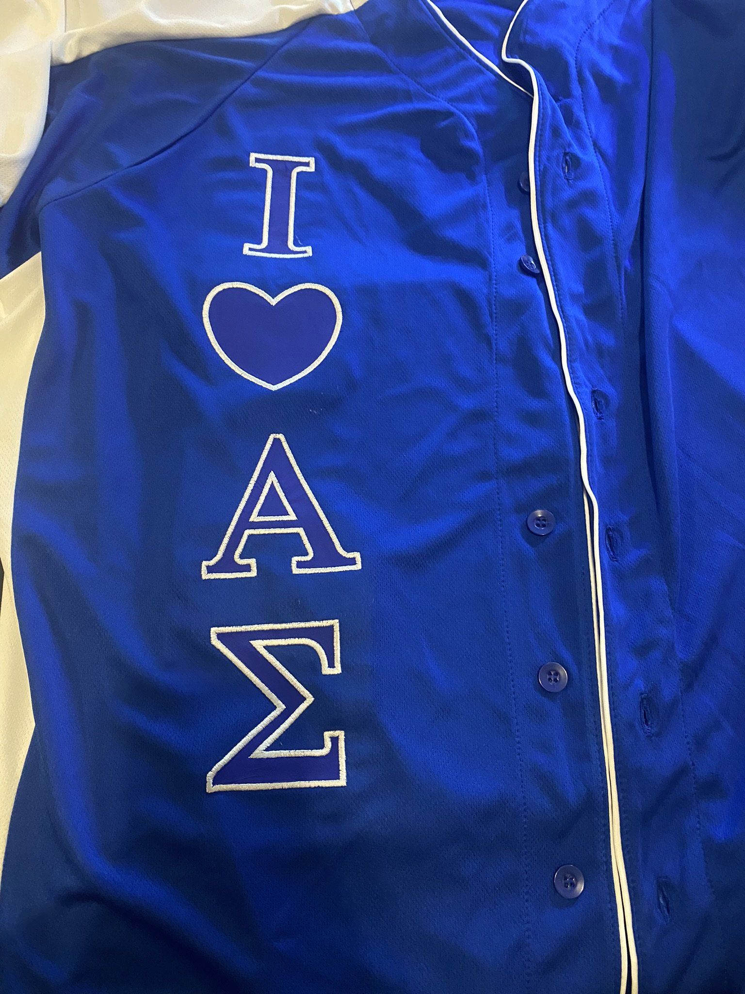 A close up of a blue shirt with the words `` i love a sigma '' embroidered on it.