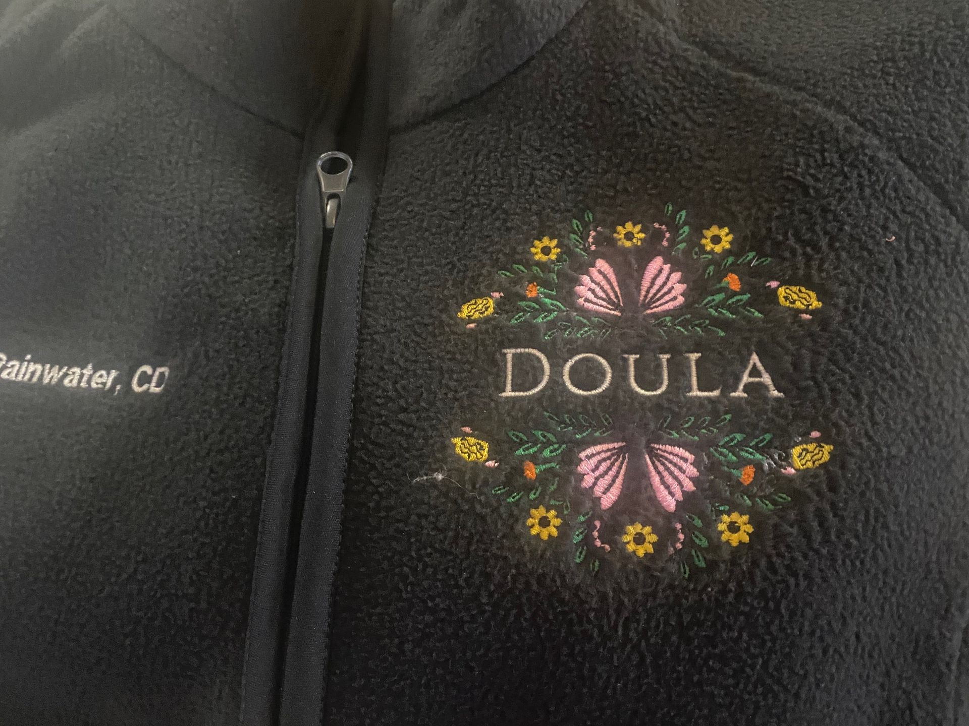 A black jacket with the word doula embroidered on it