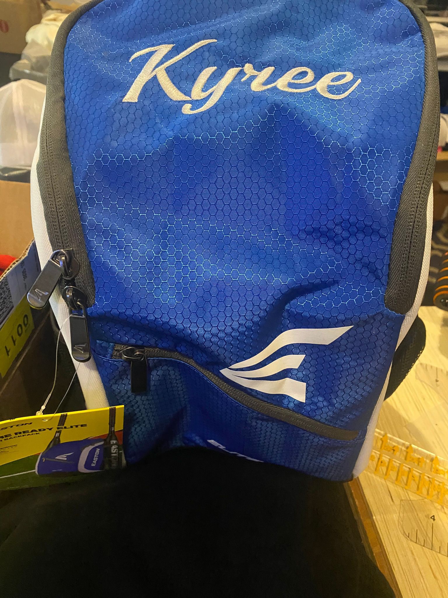 A blue and white backpack with the name kyriee on it