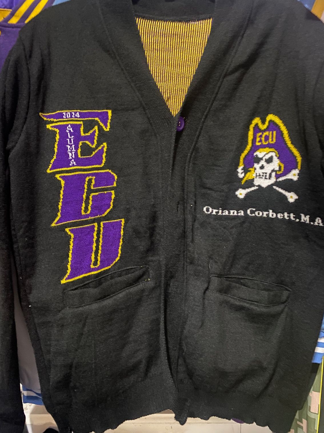 A black sweater with ecu embroidered on it