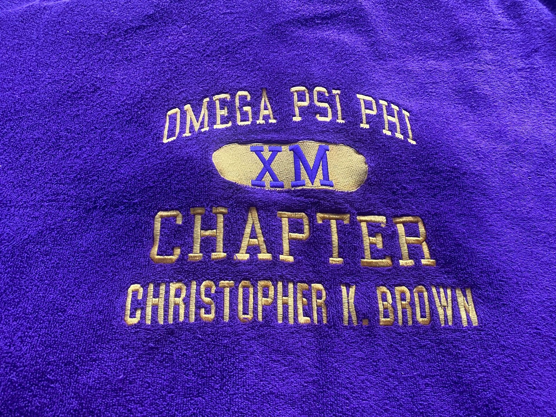 A close up of a purple towel with gold writing on it.