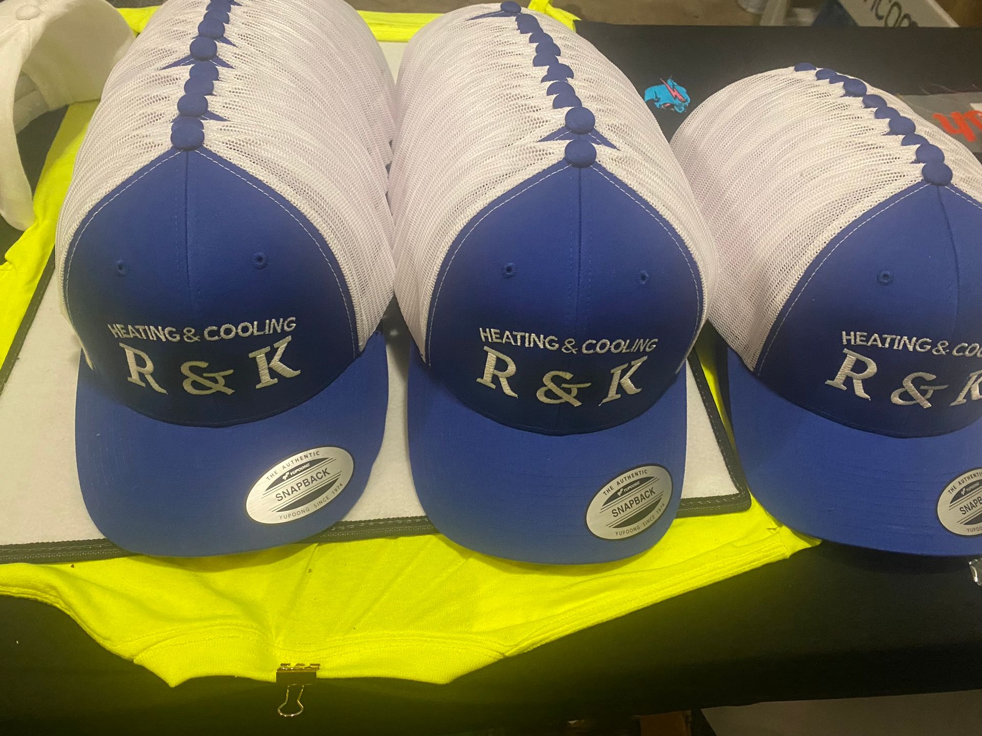 Three blue and white hats with r & k written on them