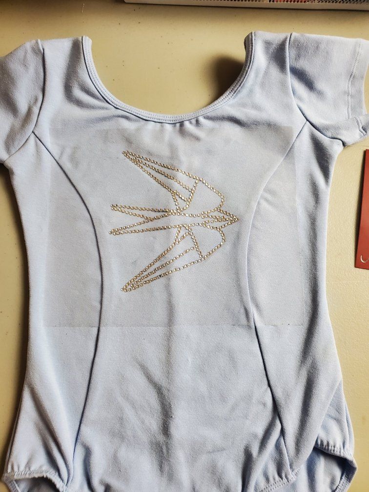 A white leotard with a bird embroidered on it