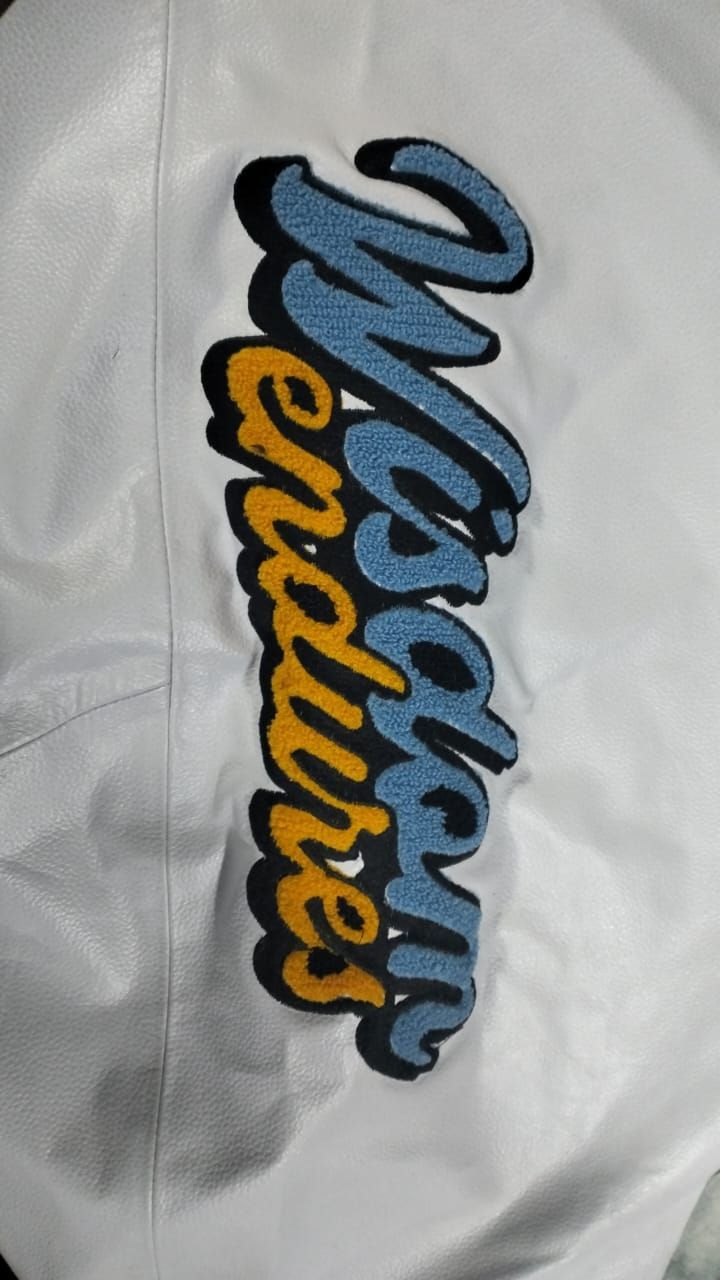 A white shirt with a blue and yellow embroidered logo