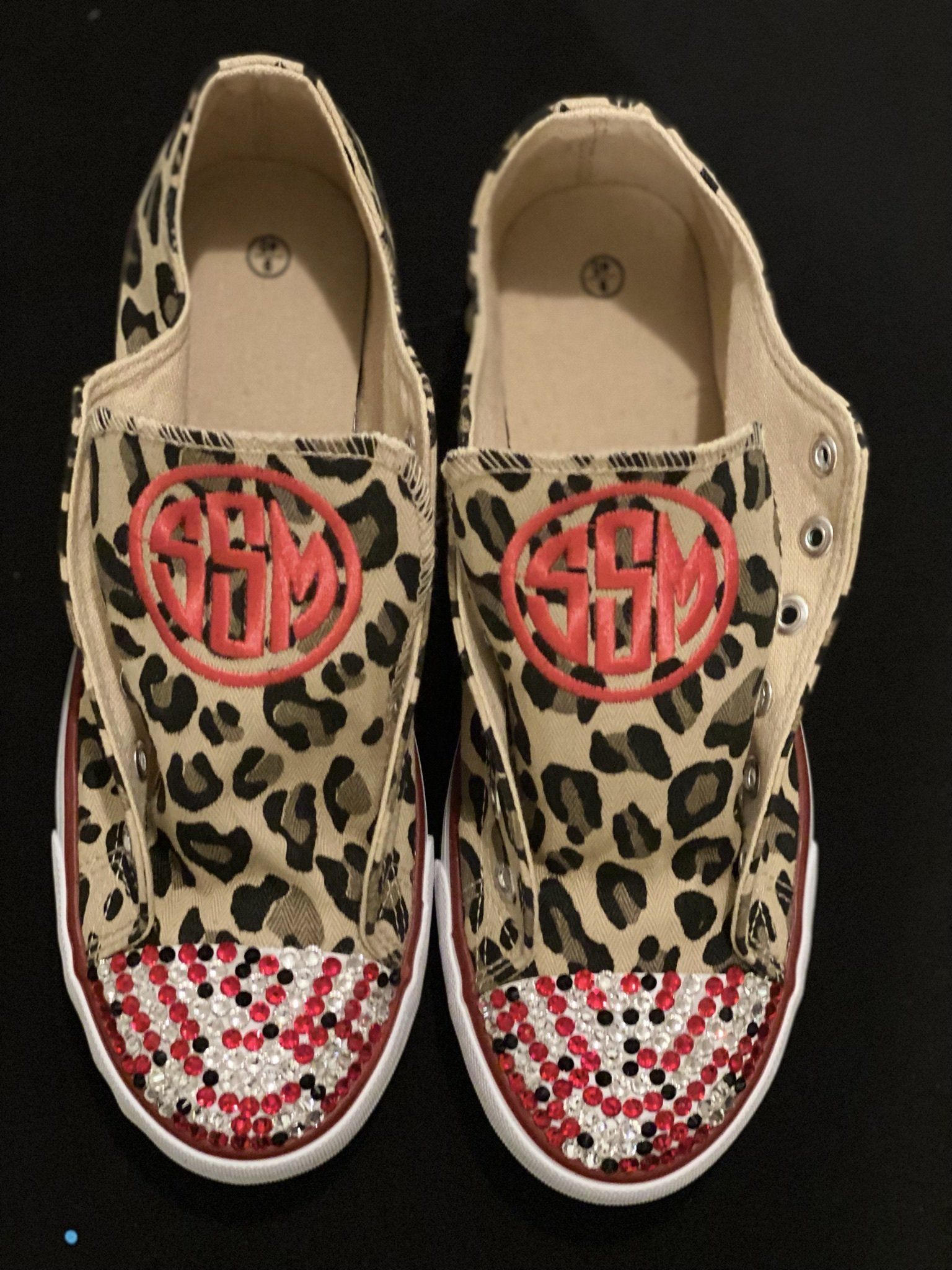 A pair of shoes with a leopard print and a monogram