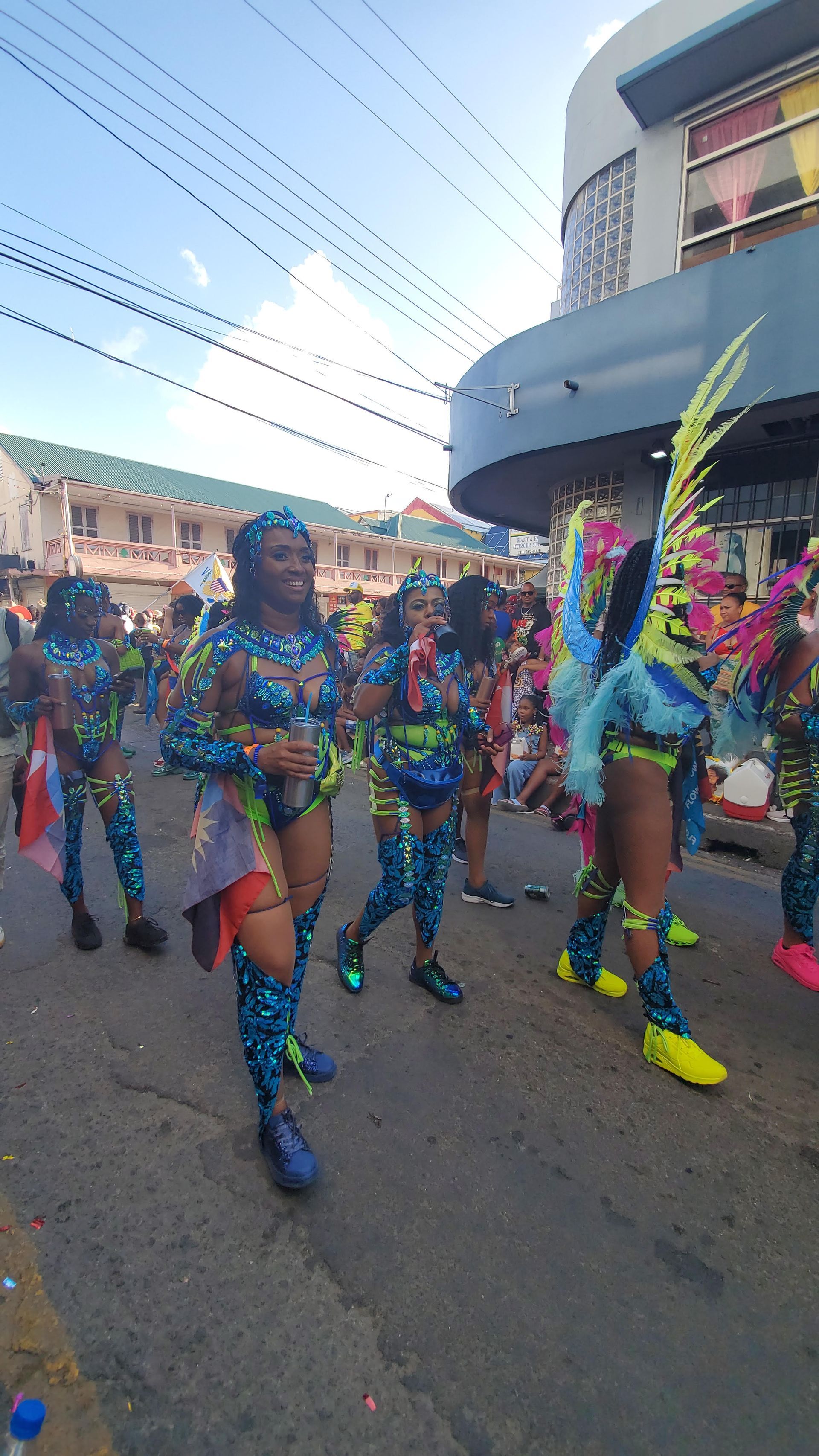 A group of people in colorful costumes are walking down a street.