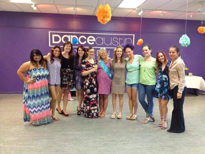 A group of women posing for a picture in front of a dance studio