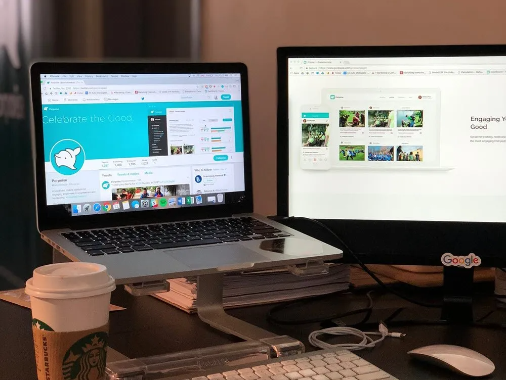 Hay una computadora portátil encima de un escritorio junto a un monitor.