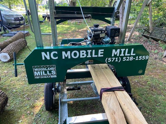 NC Mobile Mill cutting a log in a wooded outdoor setting