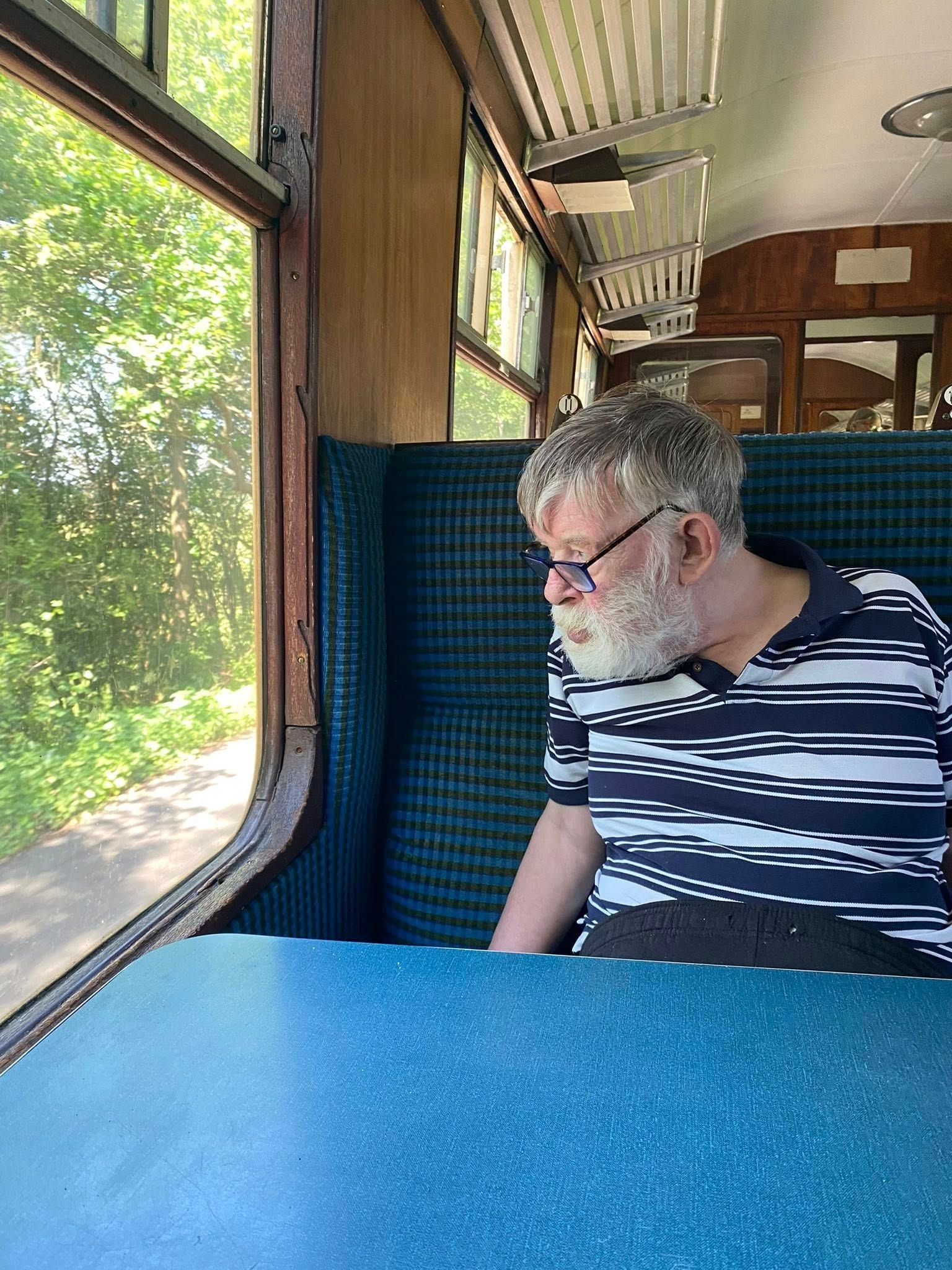 Man sitting on train, looking out the window 