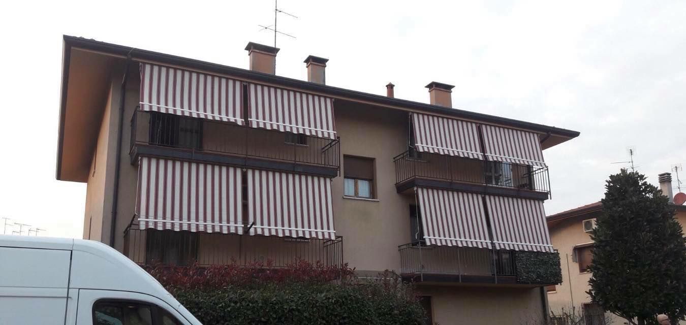 Edificio con tende a strisce sui balconi.