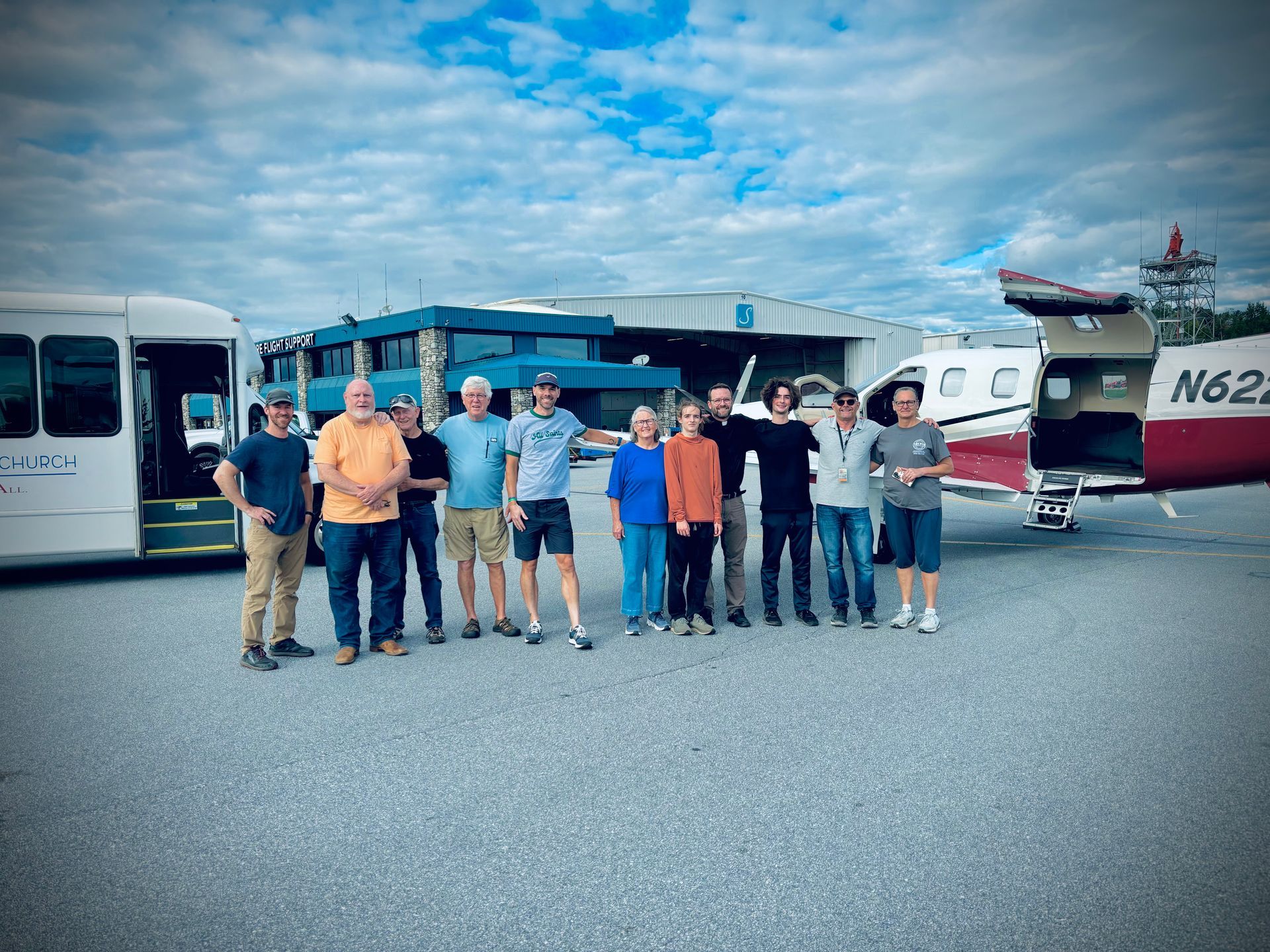 A group of people standing in front of a plane with the number n62 on it