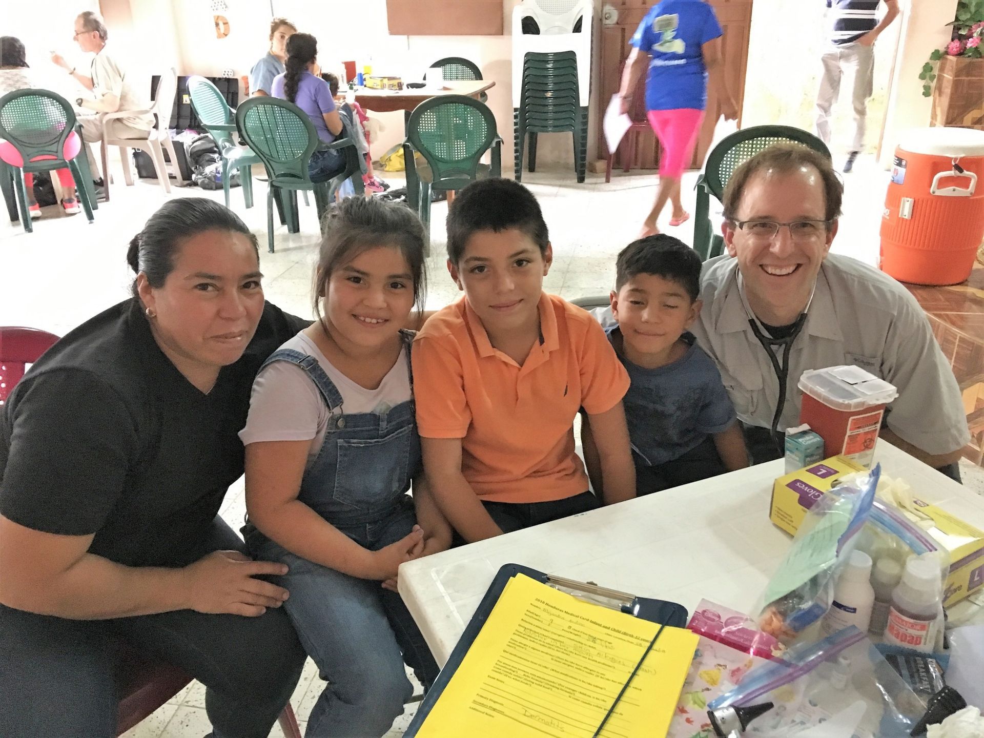 A group of people are posing for a picture while sitting at a table.