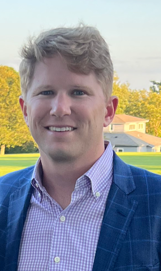 A man in a suit and tie is smiling for the camera.