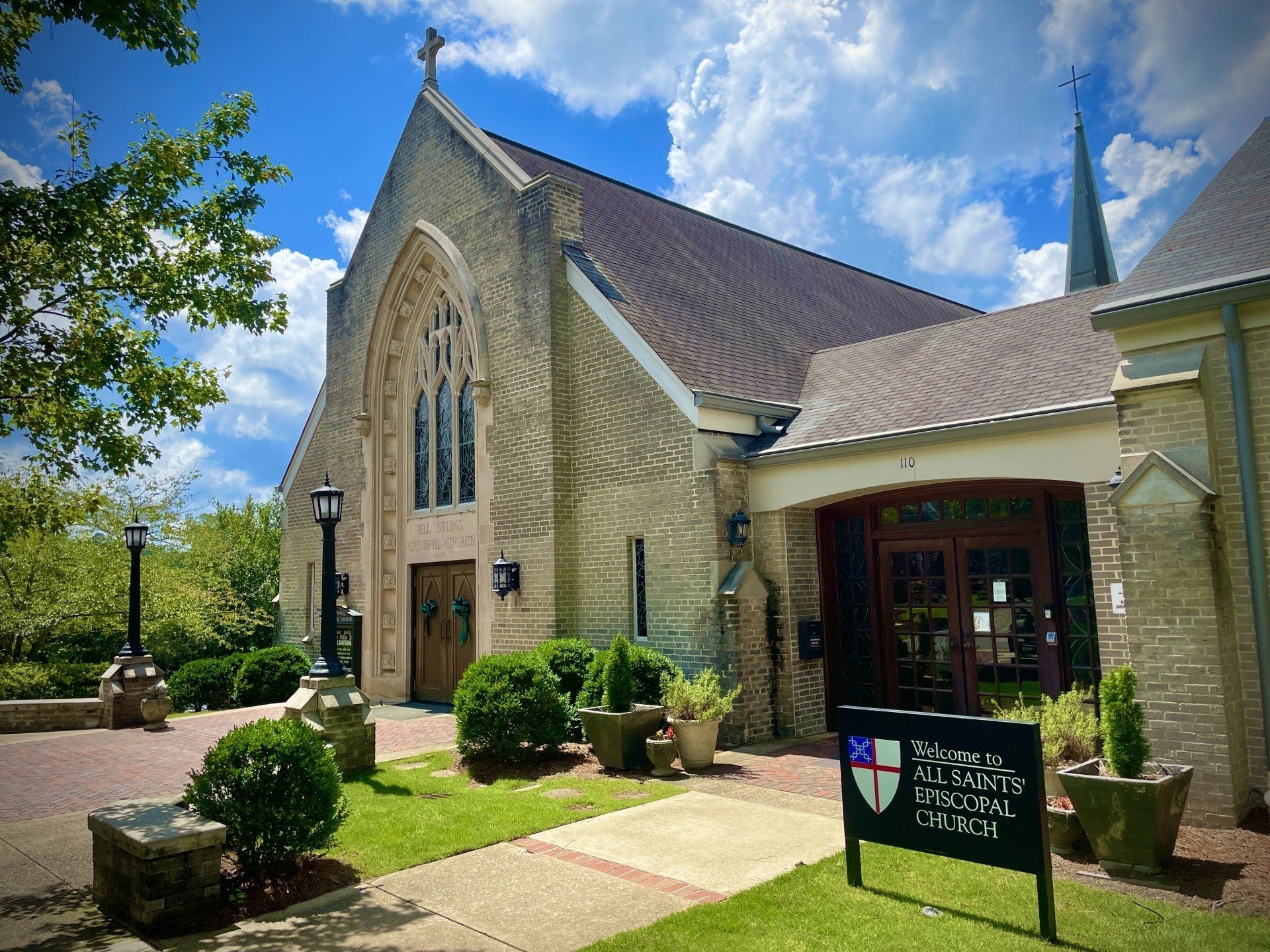 A large brick church with a sign in front of it.