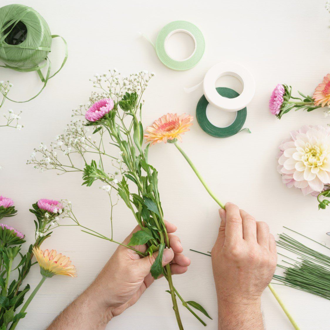 A person is holding a bouquet of flowers on a table