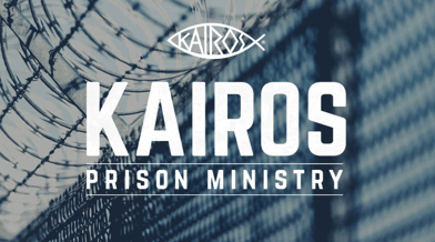 A poster for the kairos prison ministry with a barbed wire fence in the background.