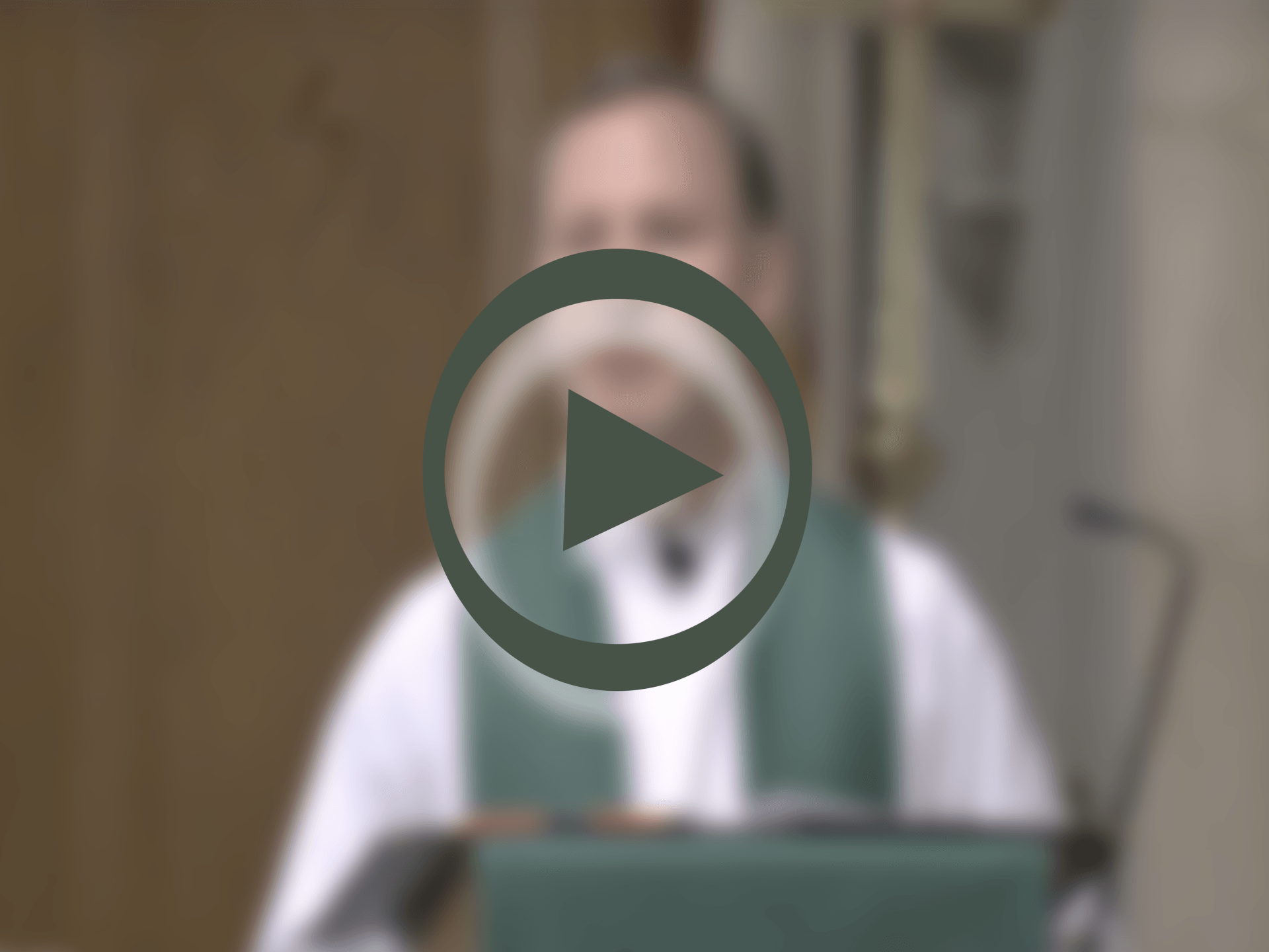 A blurry picture of a man with a play button in the middle