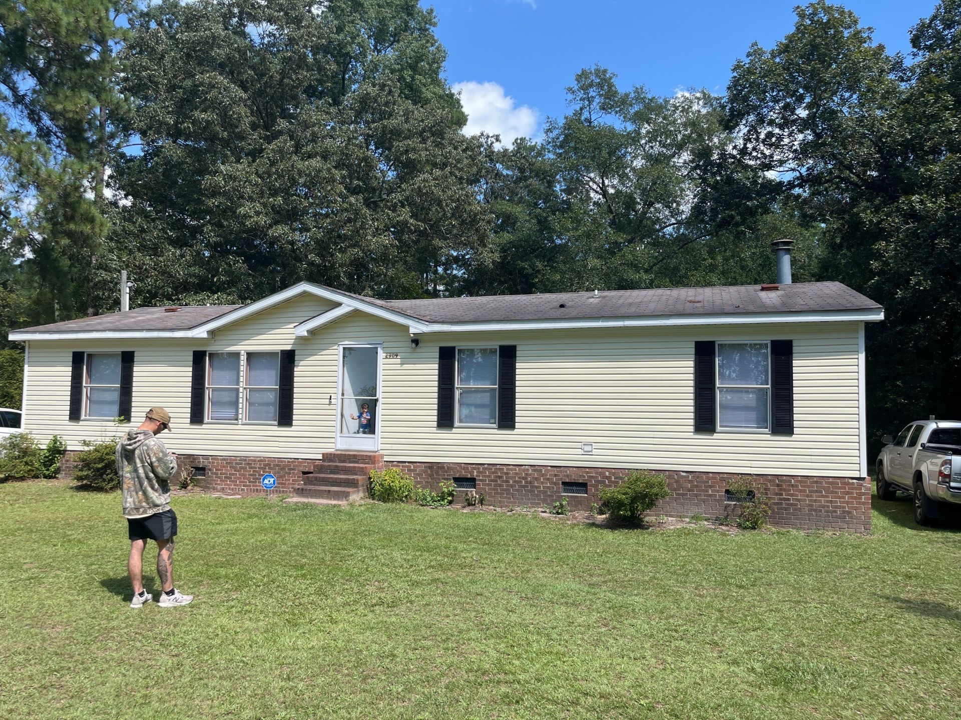 A man is standing in front of a mobile home.