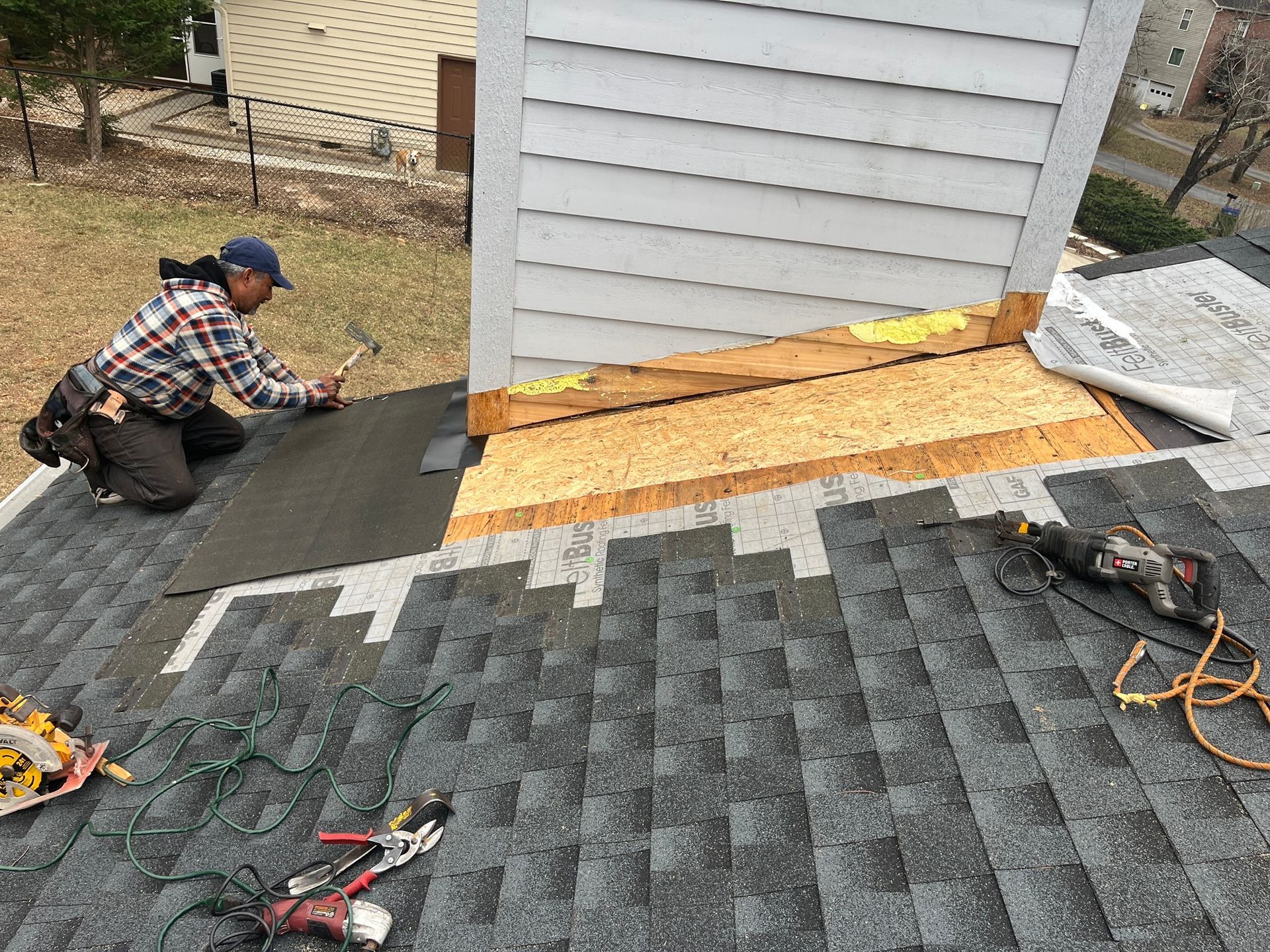 A man is working on the roof of a house.