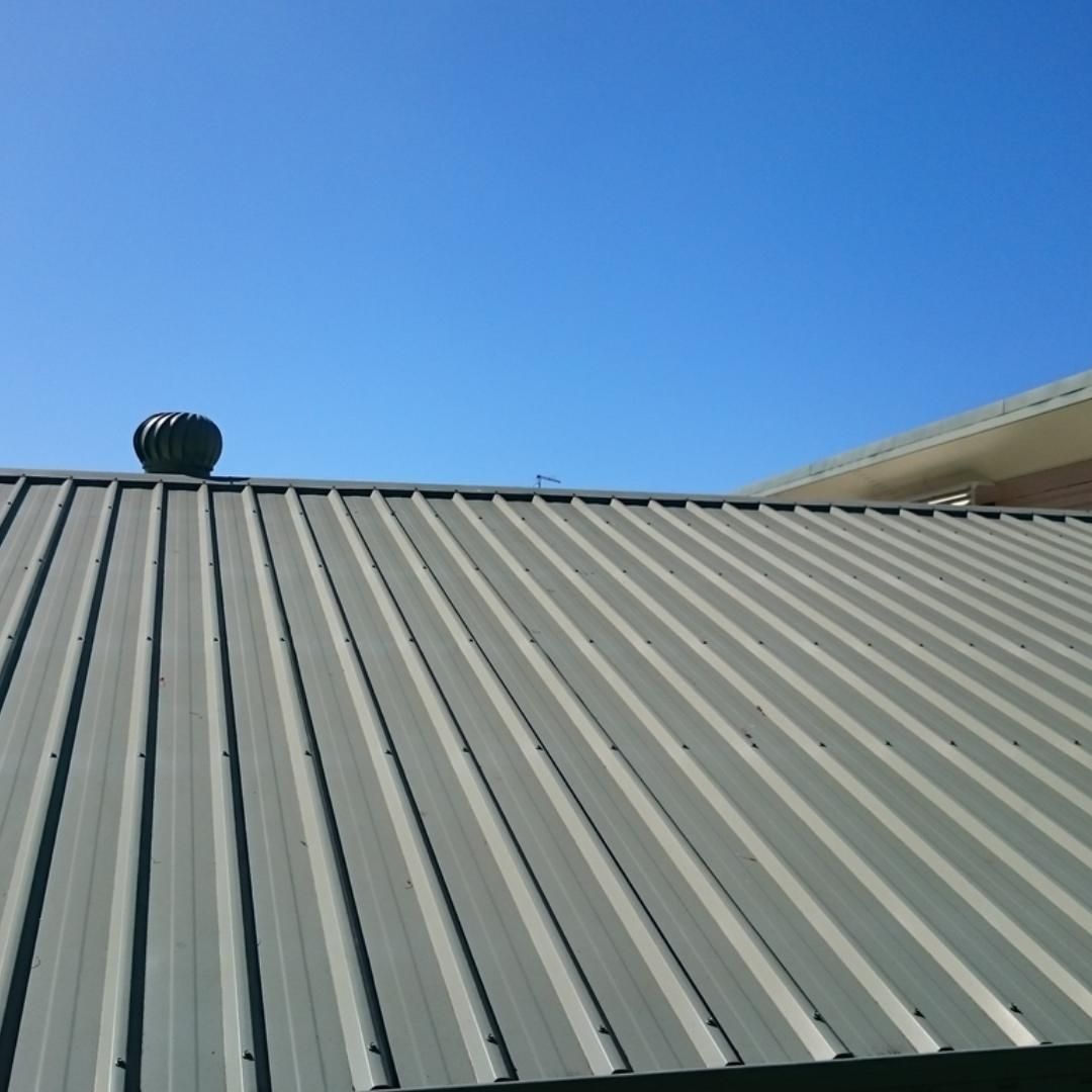 A roof with a wind turbine on top of it
