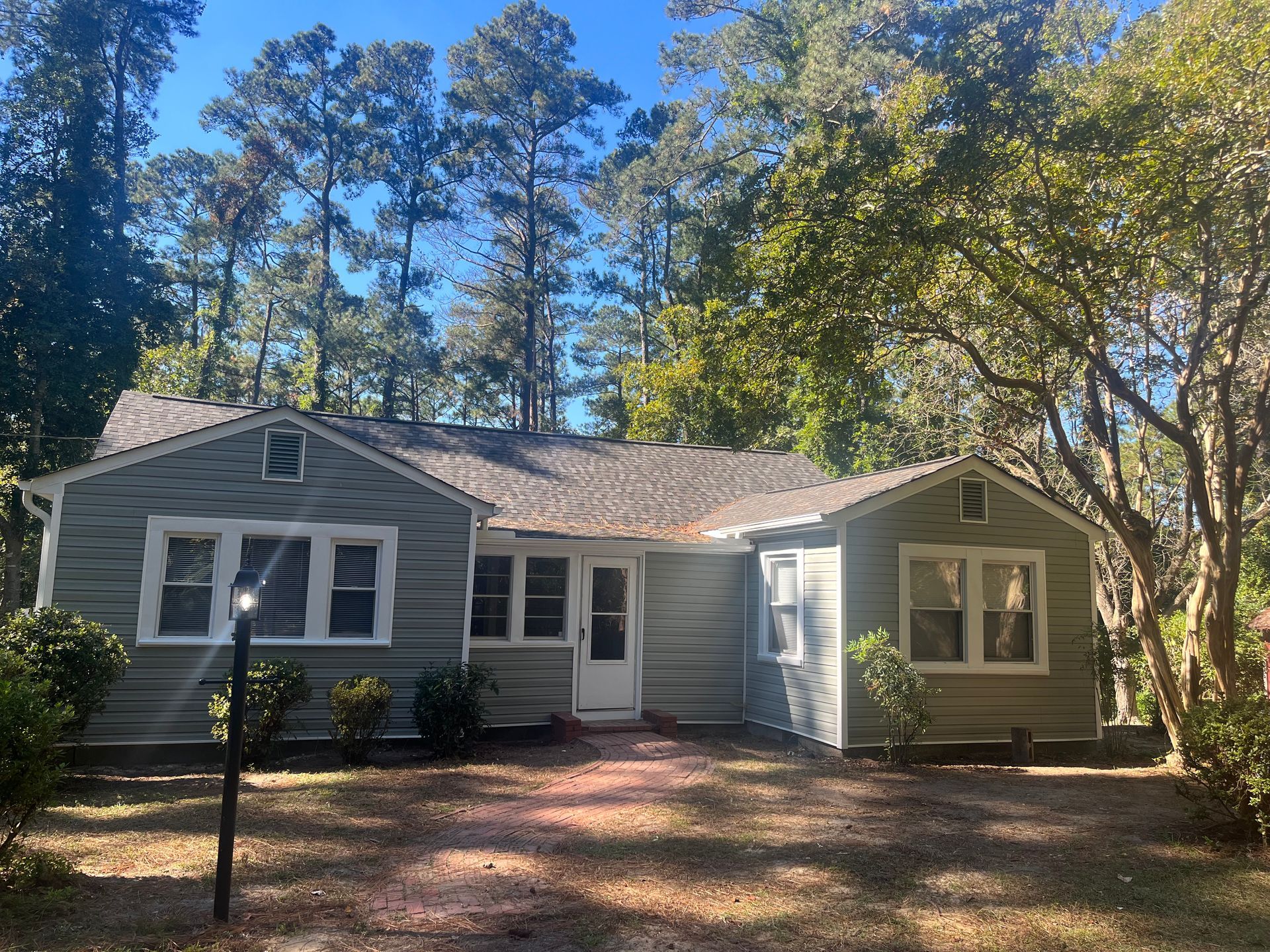 A house is surrounded by trees on a sunny day