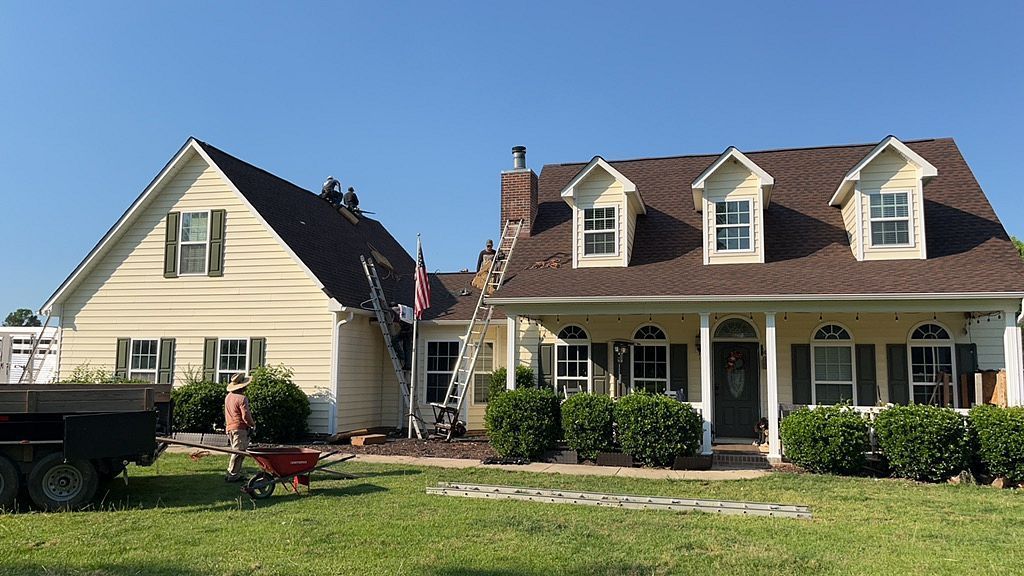 A large house with a brown roof is being remodeled.