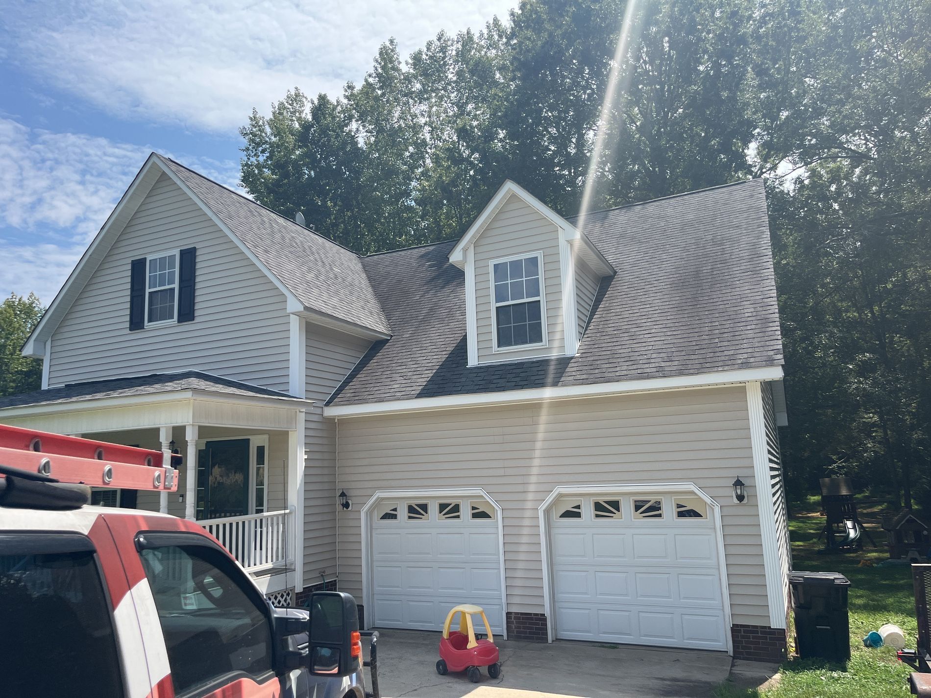 A house with two garage doors and a truck parked in front of it.