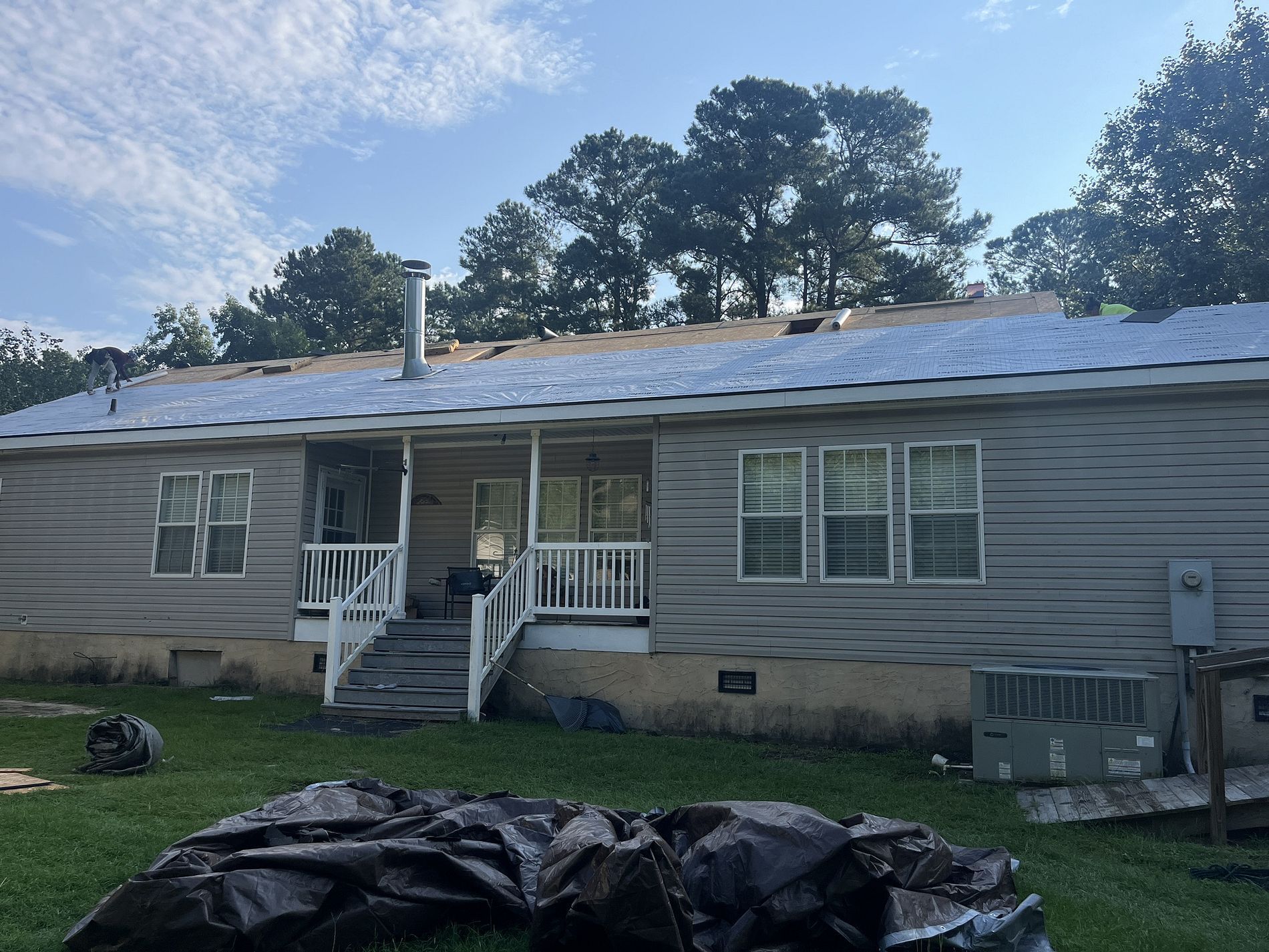 A mobile home with a roof that is being installed.