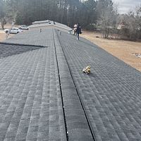 A person is standing on the roof of a house.