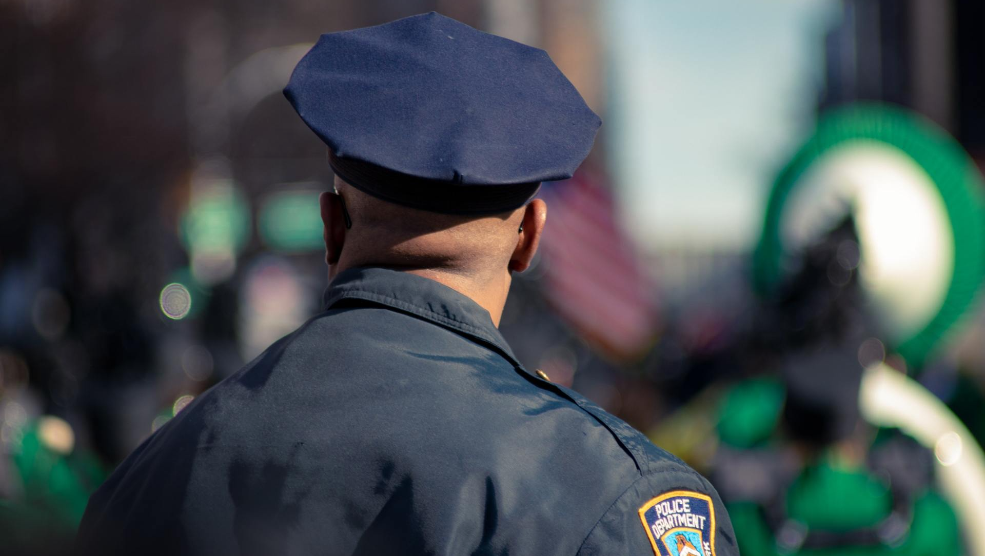 A police officer is standing in front of a crowd of people.