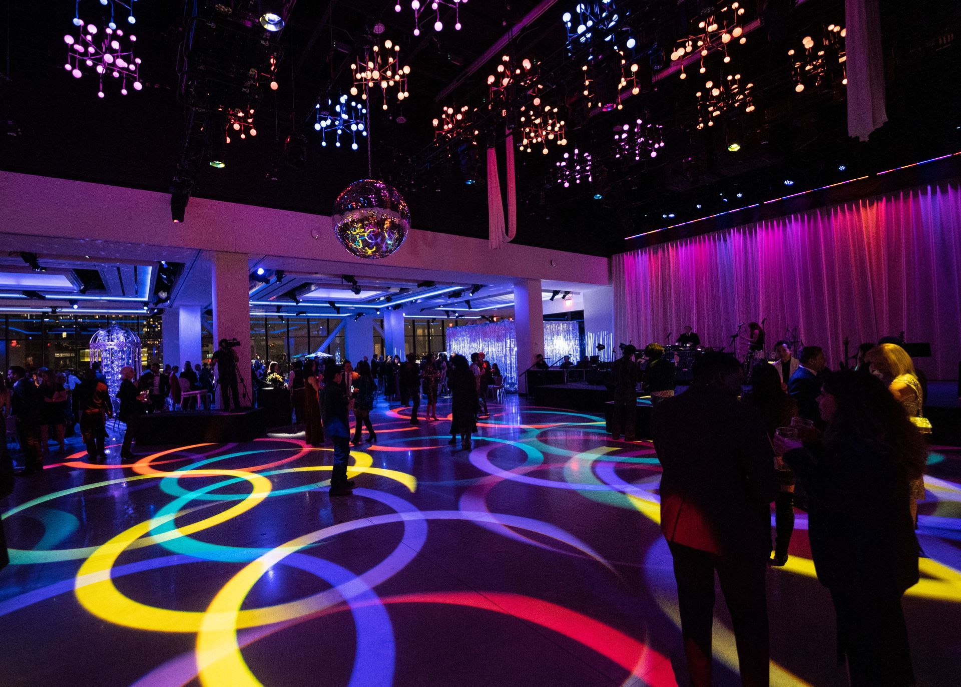 A disco ball is hanging from the ceiling of a large room