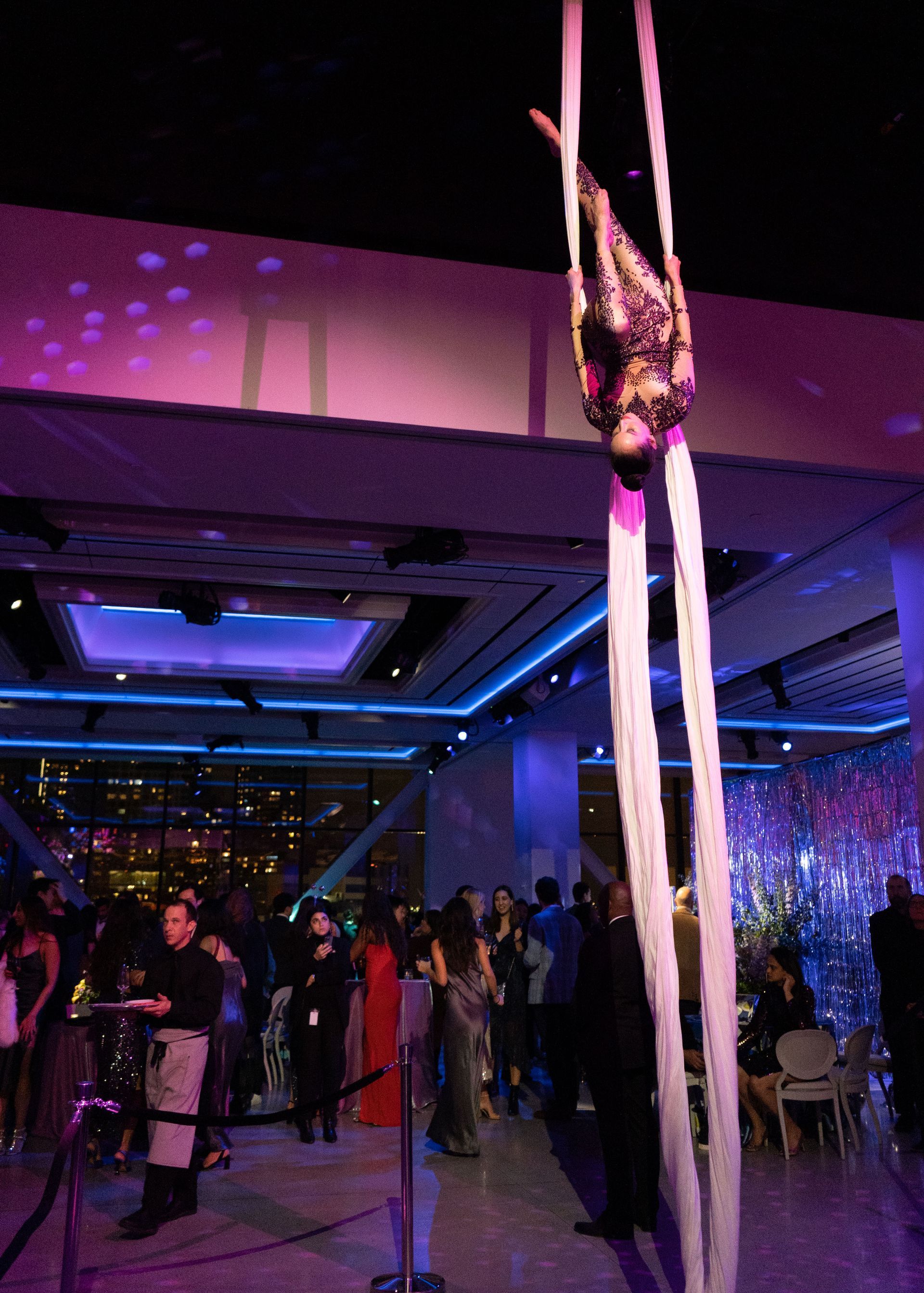 A woman is doing aerial acrobatics in a large room
