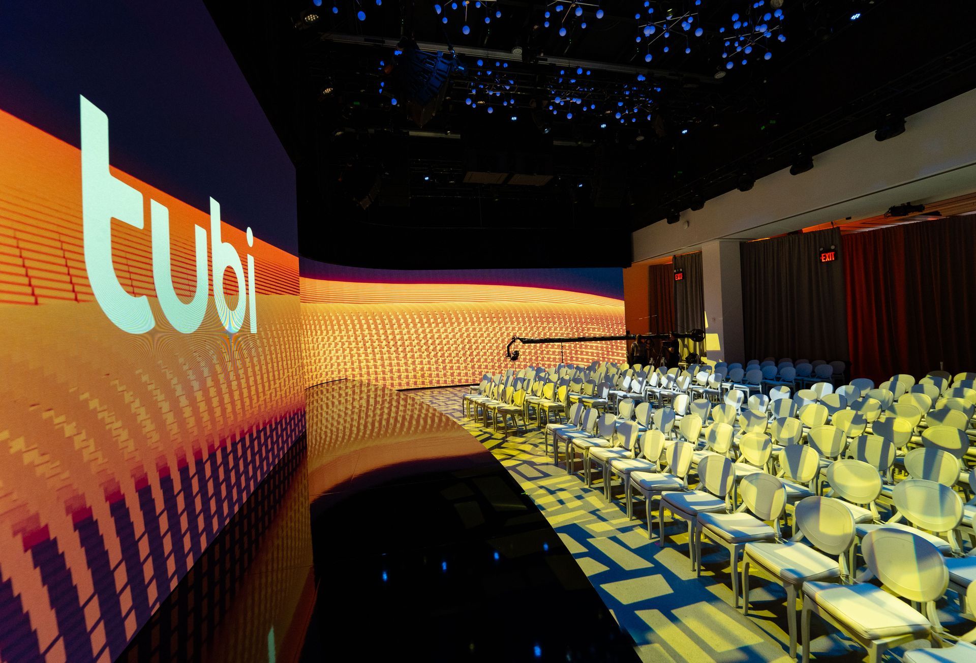 A large auditorium with a large screen that says tubi on it