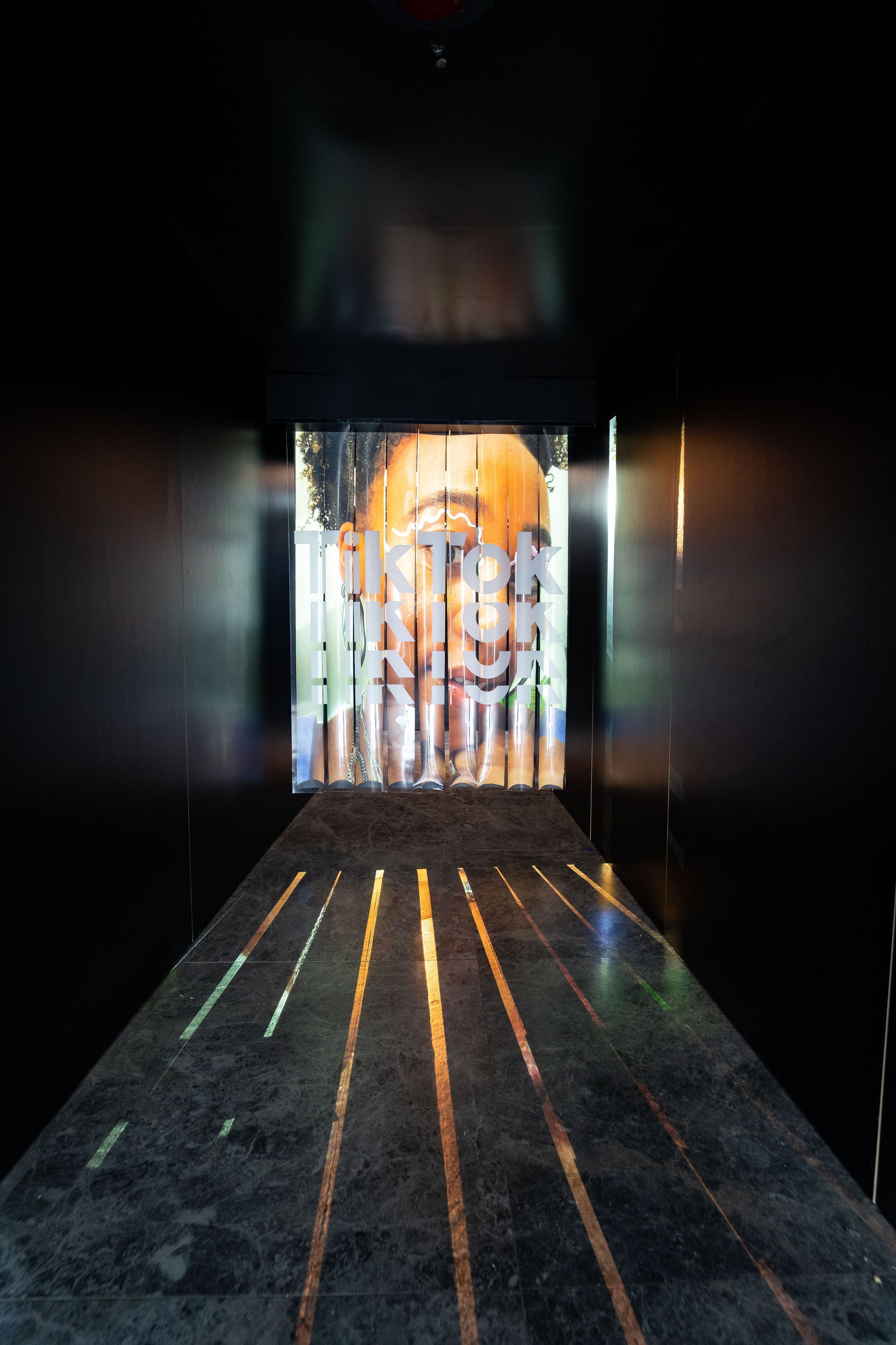 A dark hallway with a picture of a person on the wall.