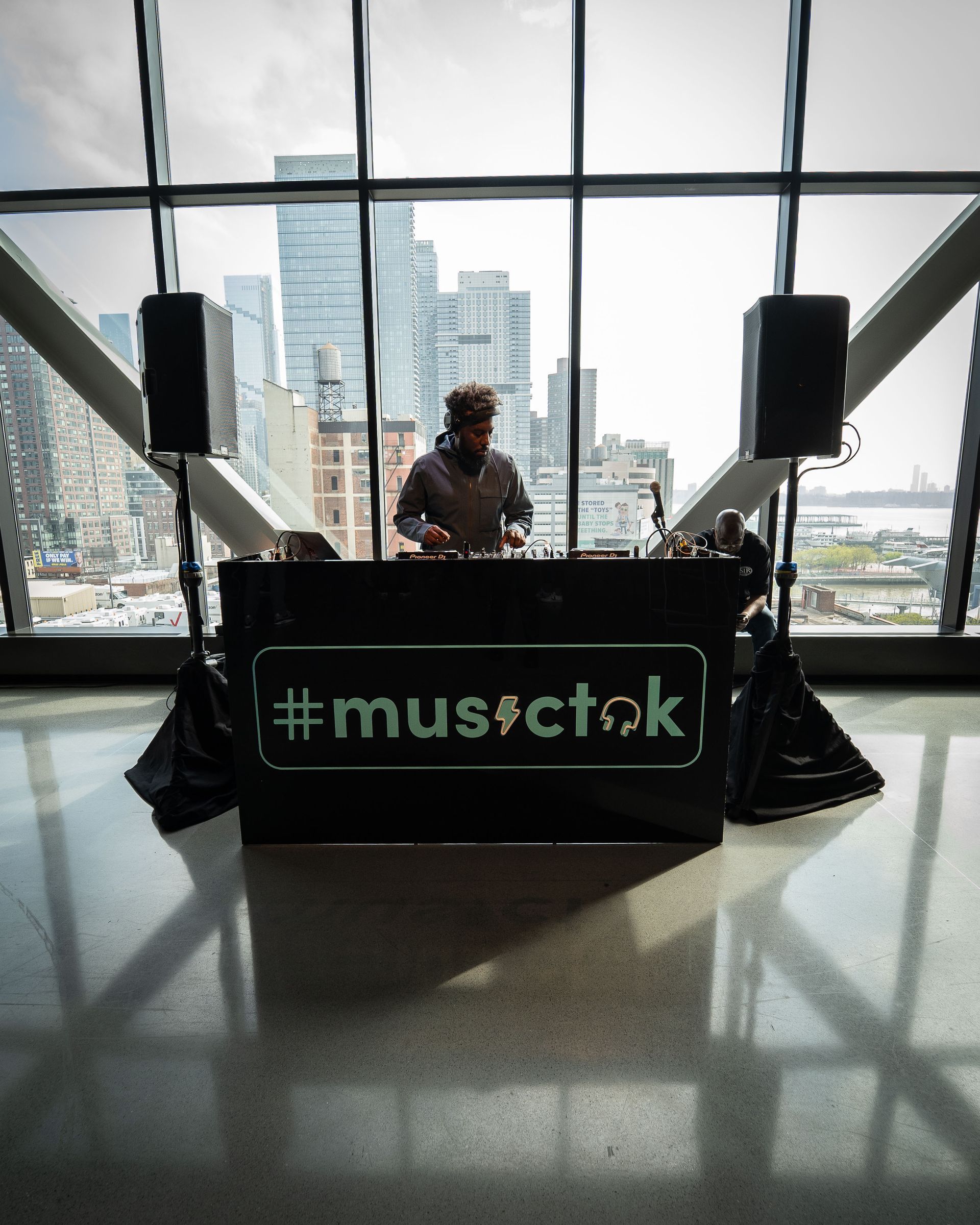 A man is behind a dj booth that says #musictok