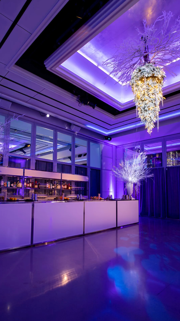 A large room with purple lights and a chandelier hanging from the ceiling.
