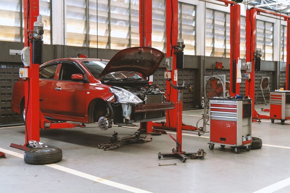 A Car is Sitting on a Lift in a Garage — P & R Automotive Services in Pialba, QLD