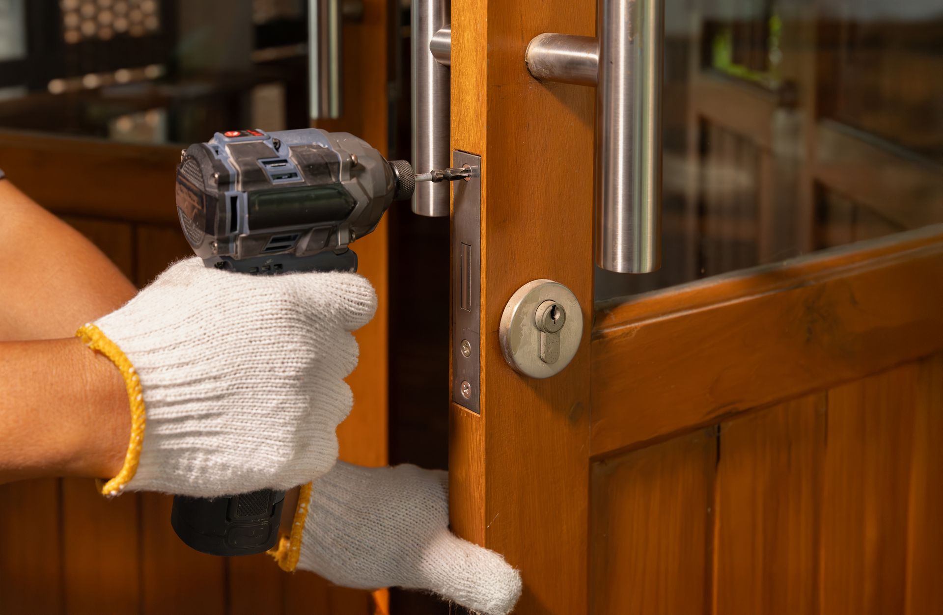 Locksmith repairing dining room door lock after forced entry damage.