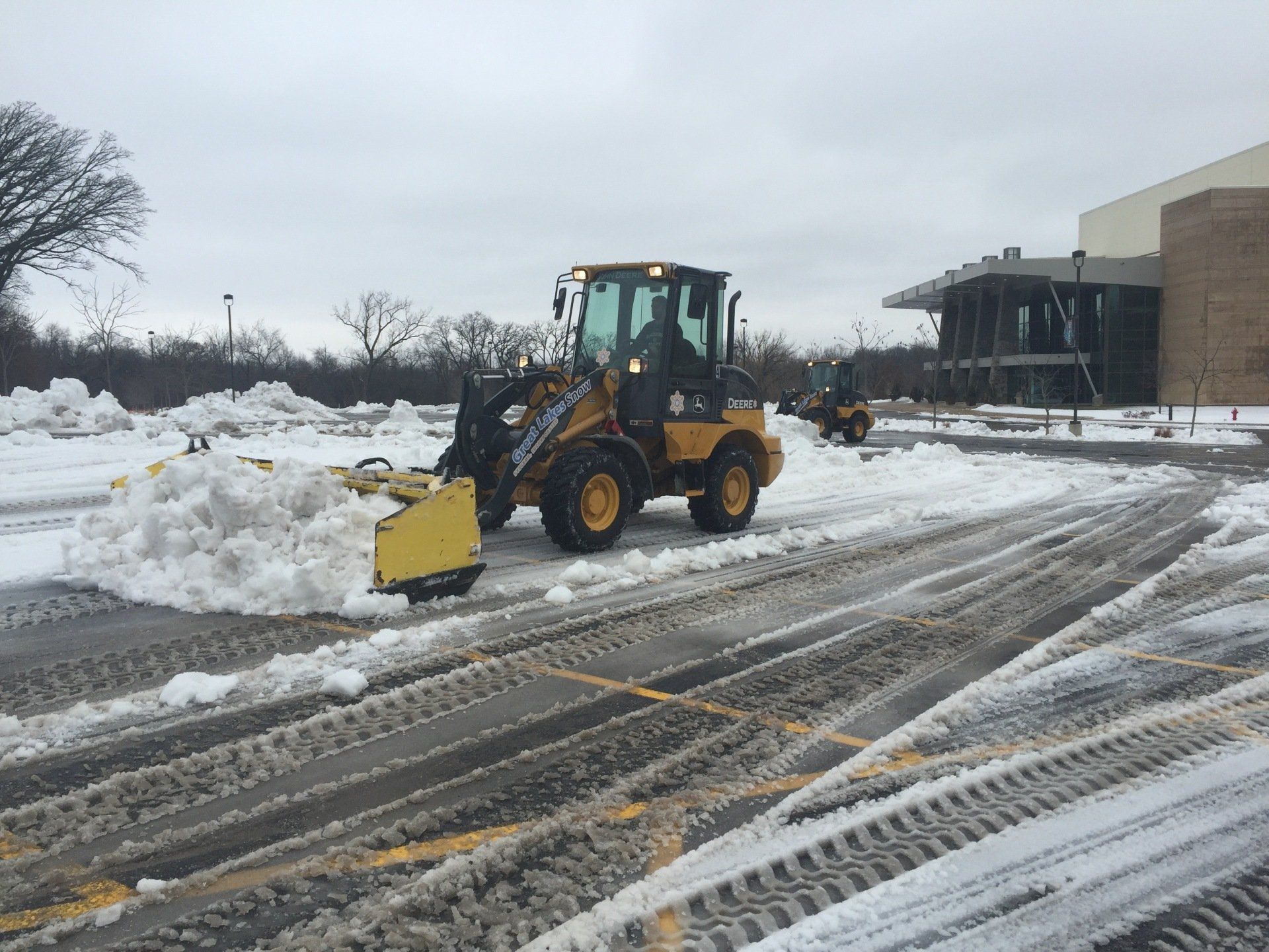 Great Lakes Snow loaders clearing a commercial parking lot after heavy winter snowfall.