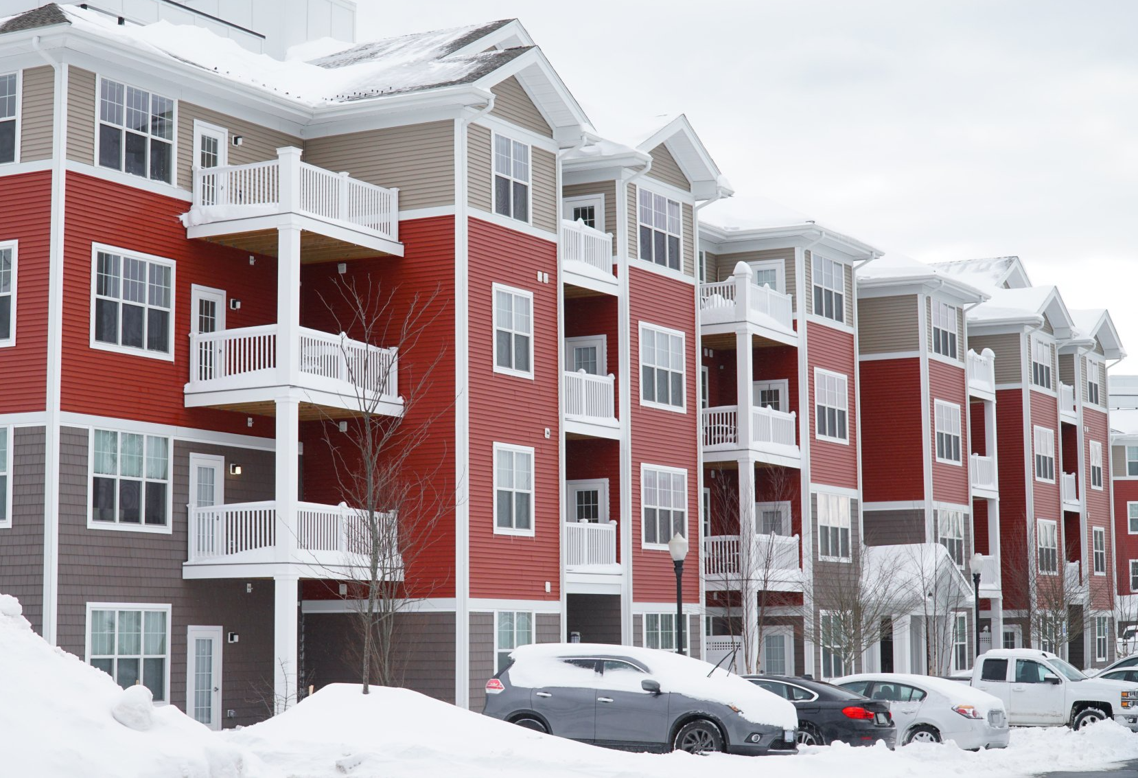 Snow-covered apartment complex showing need for reliable winter maintenance for large properties.
