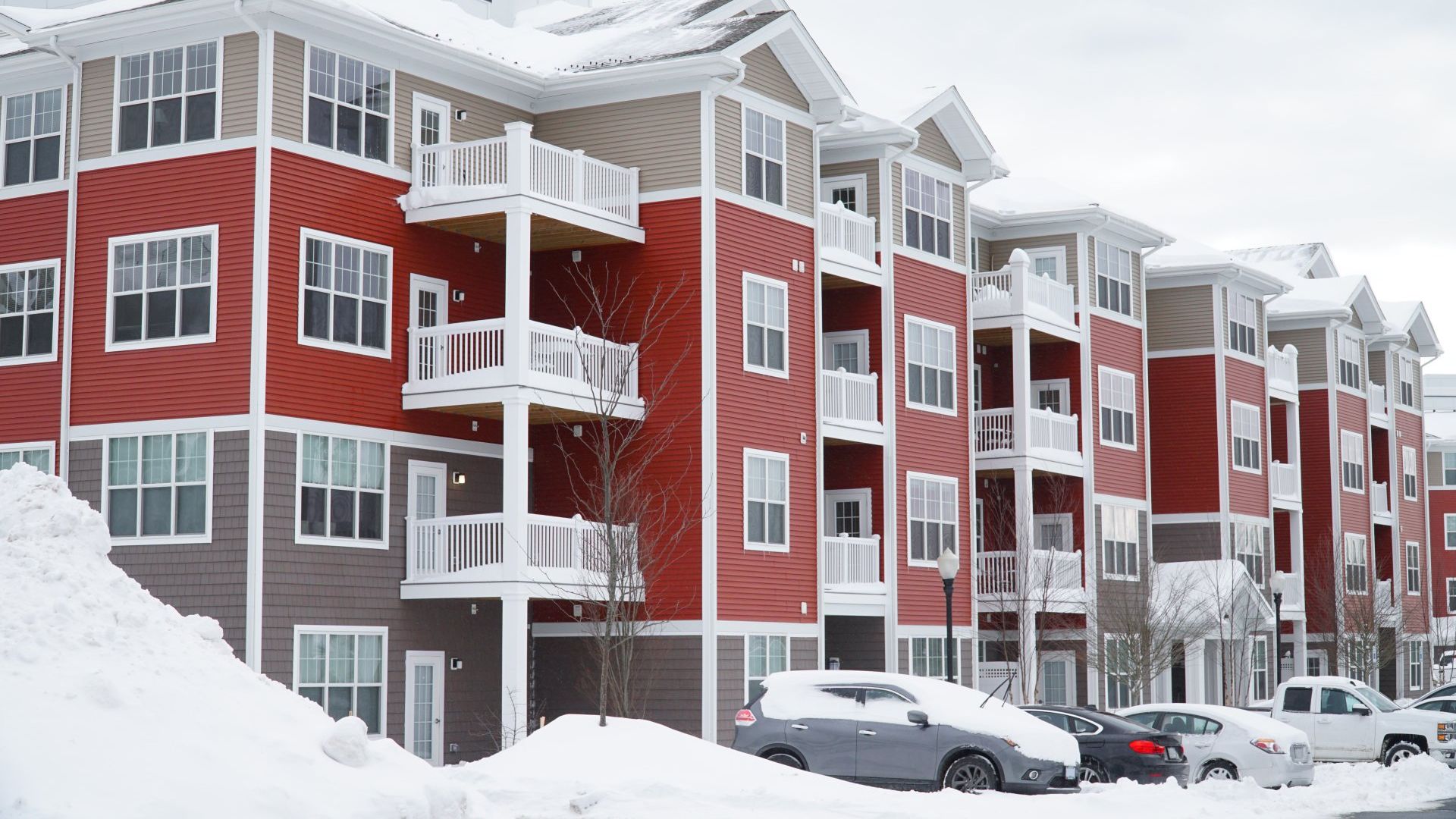 Snow-covered apartment complex showing need for reliable winter maintenance for large properties.