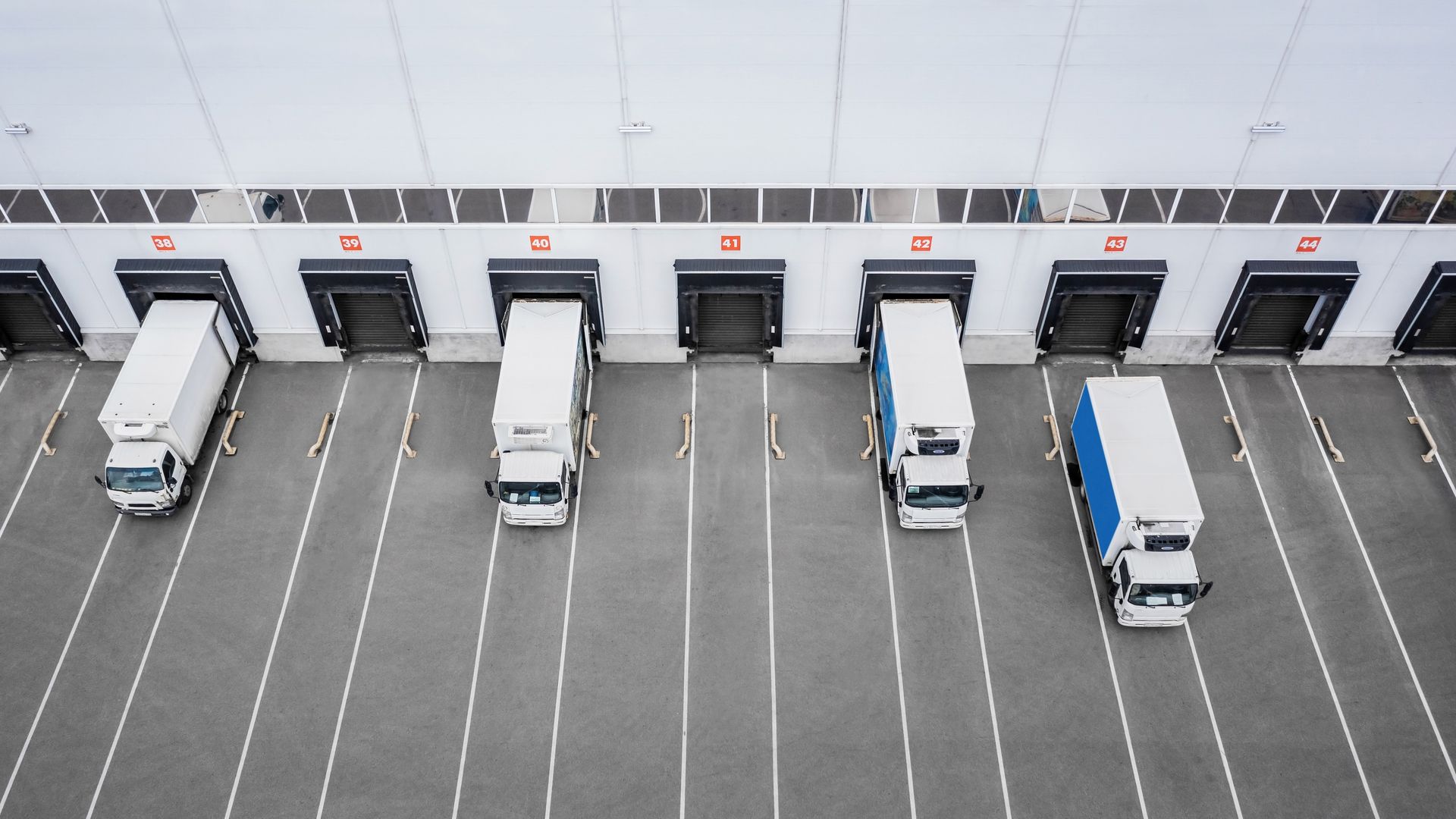 Commercial warehouse loading docks with delivery trucks parked in marked bays