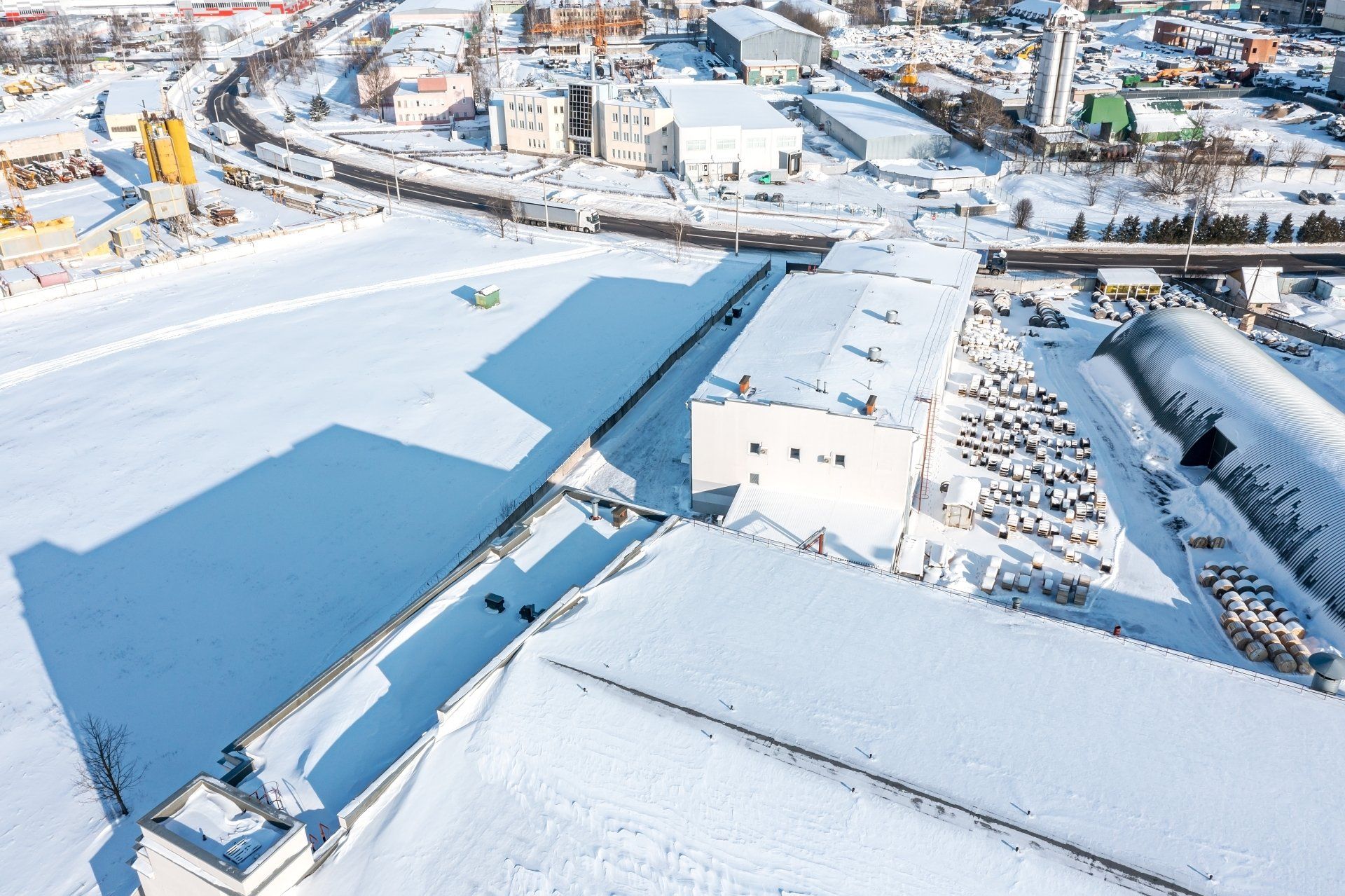 Aerial view of snow-covered industrial facility highlighting need for large-scale winter maintenance.
