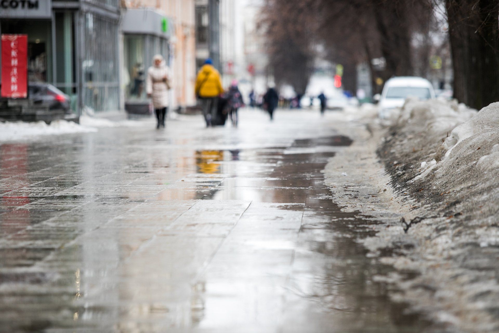 slushy and snow filled street with people walking