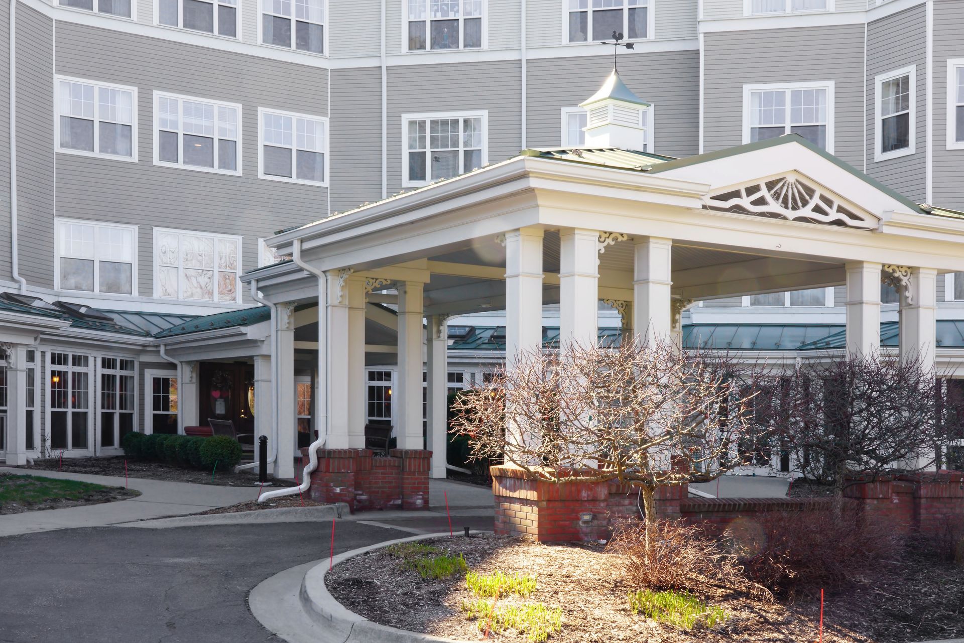 Large senior living or healthcare facility entrance with covered drop-off area