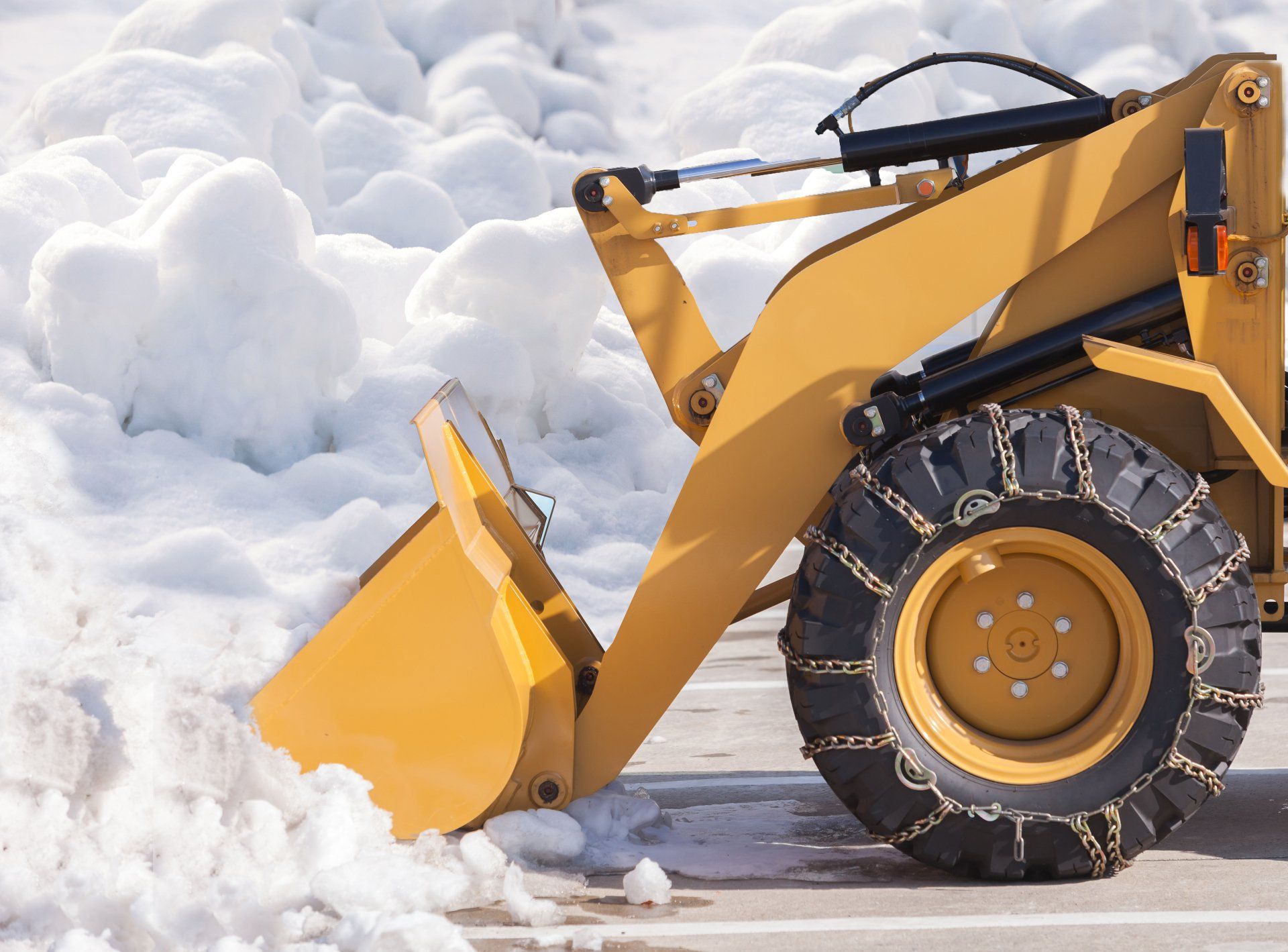 Yellow snowplow pushing snow on a snowy road