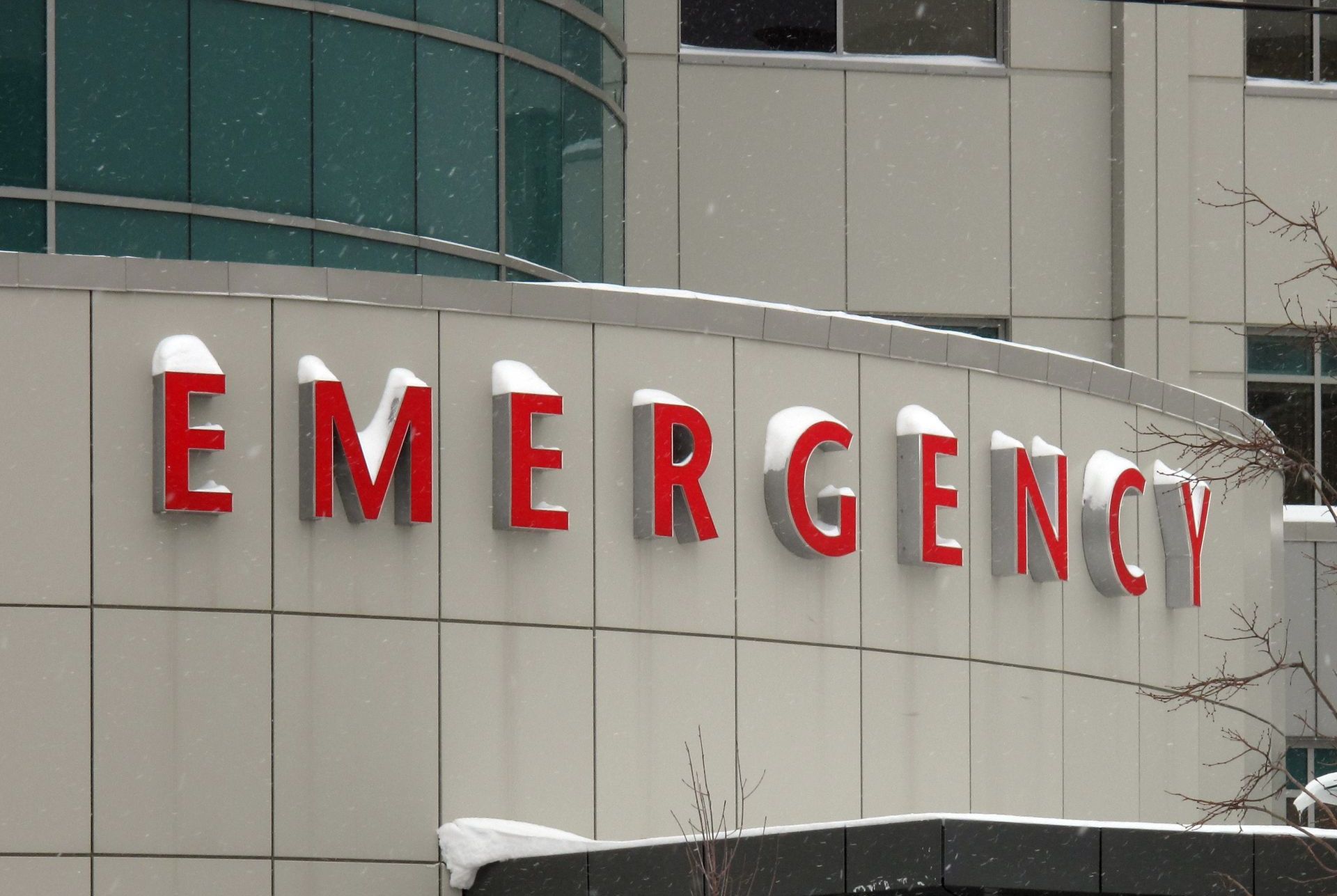 Snow on hospital emergency entrance signage showing need for reliable winter safety services.