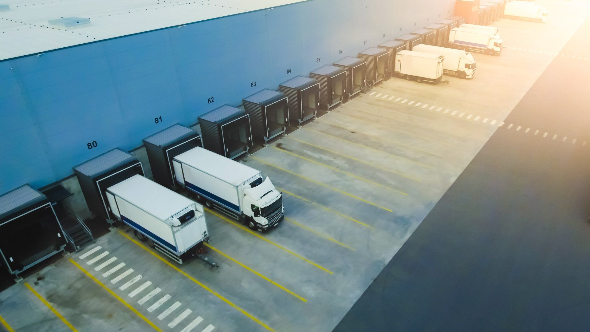 Loading dock and fleet trucks at a logistics facility highlighting need for winter maintenance.